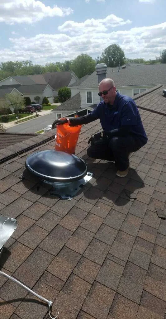 Roof-mounted attic ventilation fan being wired in