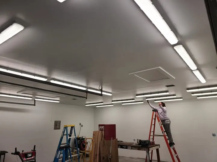 Rows of LED strip lighting installed across a workshop ceiling