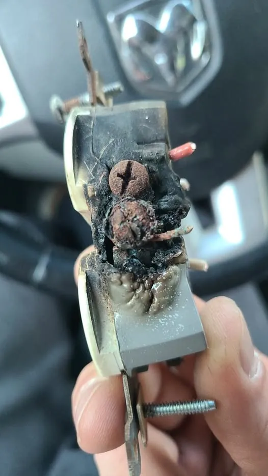 A burnt and melted electrical receptacle removed from a wall